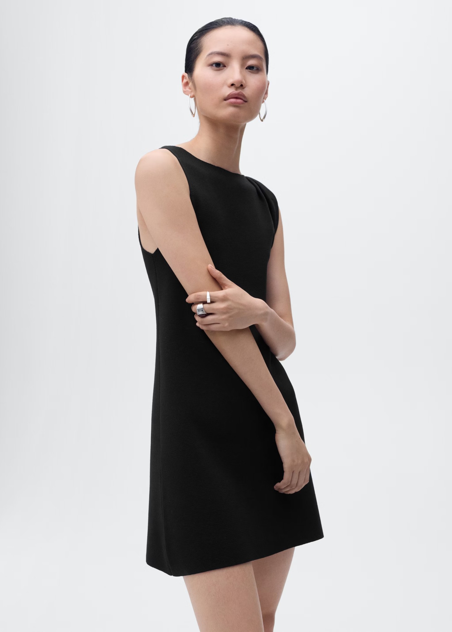 Model wearing a black asymmetrical strappy knit dress